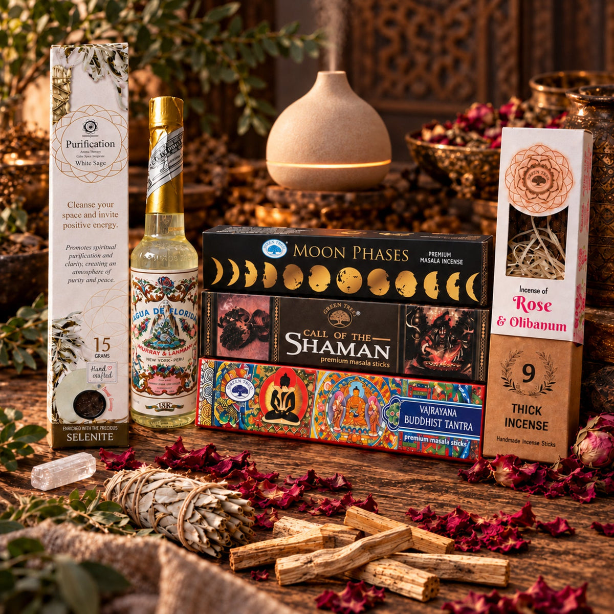 Mystic Aromas collection featuring incense boxes, Florida Water, an aroma diffuser, dried botanicals and wood sticks on a wooden table.