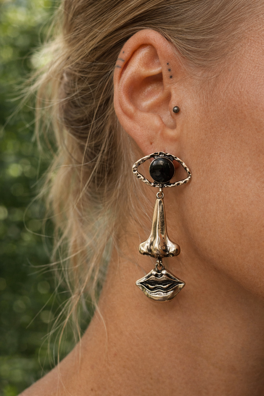 Nomad style gold earrings worn on ear