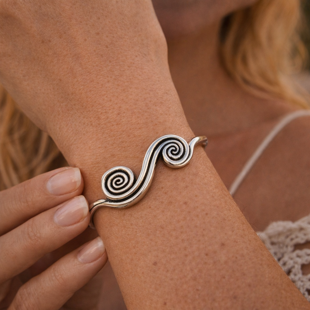 Close-up of a boho silver-tone open cuff bracelet with two raised spiral details