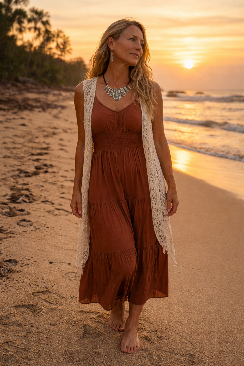 Model wearing a boho silver-tone statement necklace and matching geometric drop earrings in a Bali beach background