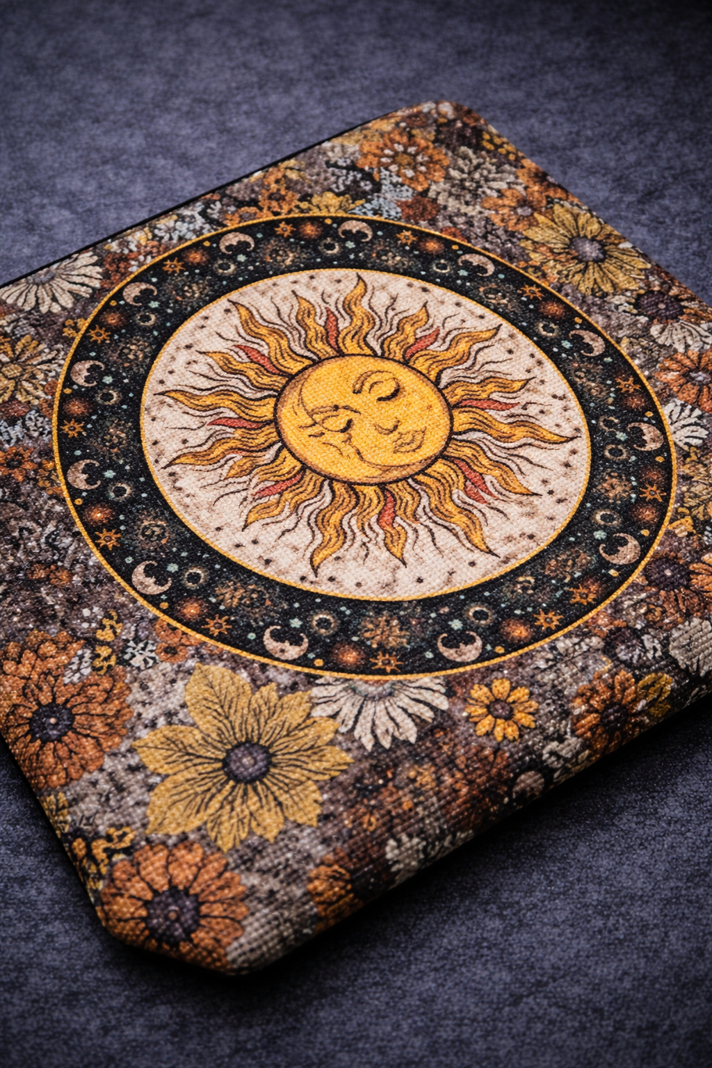 Close-up of a zippered pouch with a smiling sun, moon phases and warm-toned floral print
