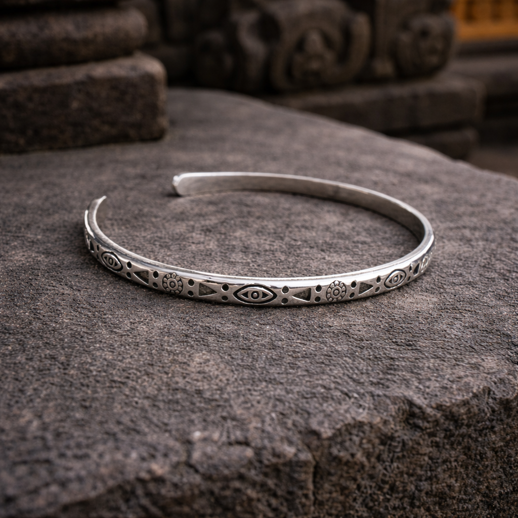Padang Padang Pulse Cuff Bracelet with an open silver-tone band and repeating eye and geometric motifs