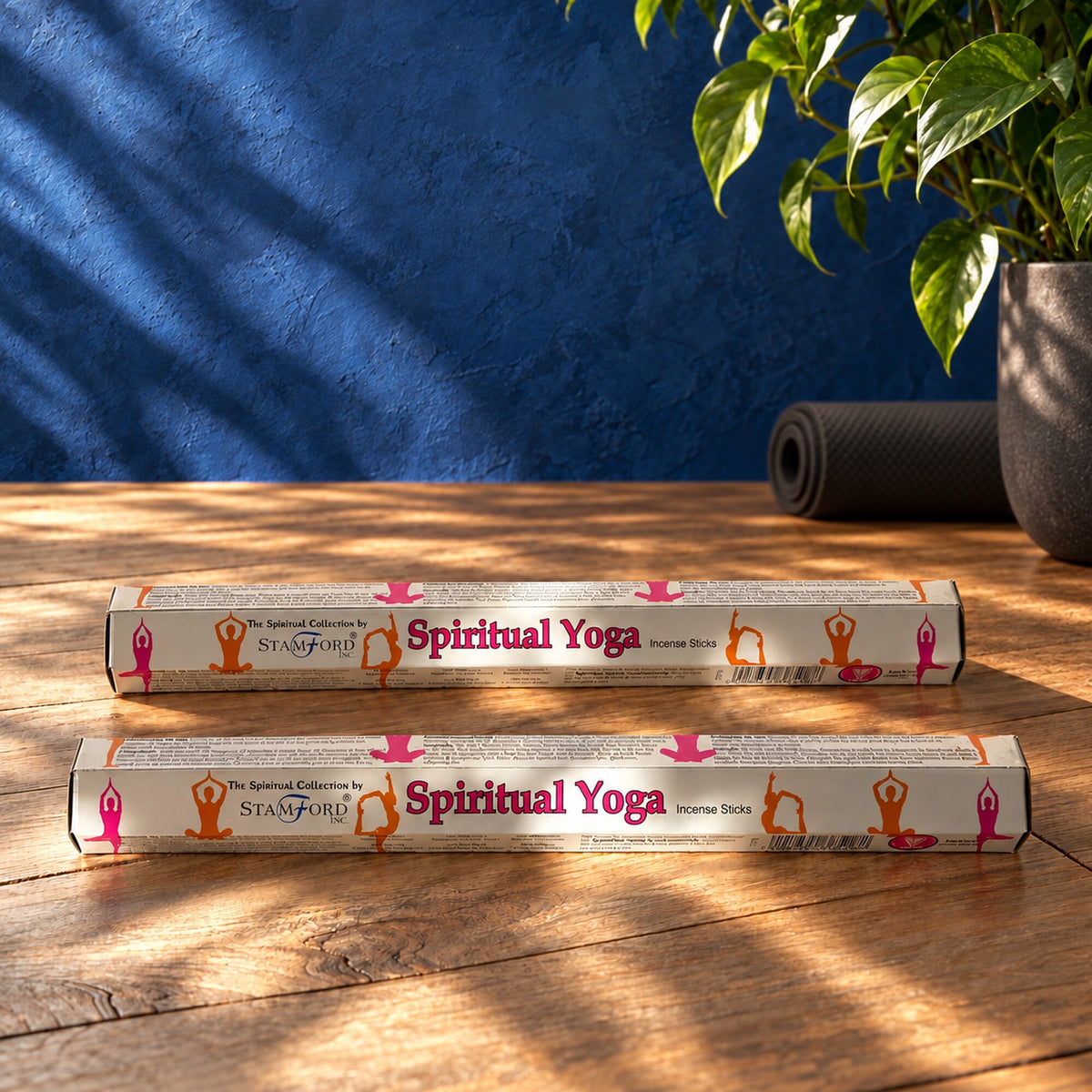 Stamford Spiritual Yoga vanilla and camomile incense sticks in white packaging on a wooden table beside a yoga mat.