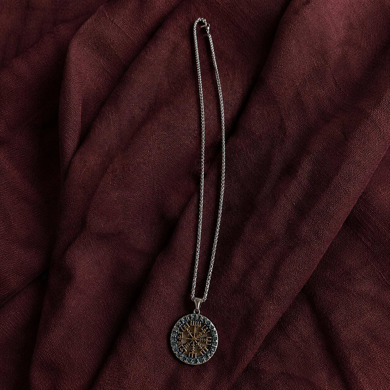 Silver-tone chain necklace with a round Vegvísir rune pendant featuring a gold-tone compass symbol and dark runic border.